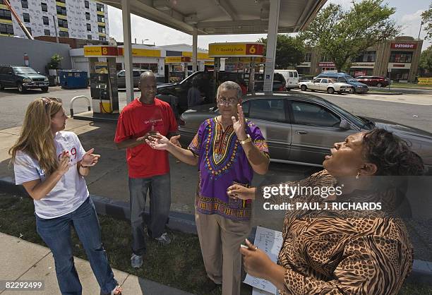 Pray At the Pump founder and leader Rocky Twyman , Angela Stevens , Kenneth Anderson and Jocelyne McClure sing a gospel song after thanking God in...