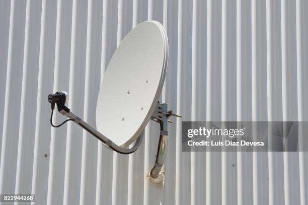 satellite dish on corrugated iron - voelspriet stockfoto's en -beelden
