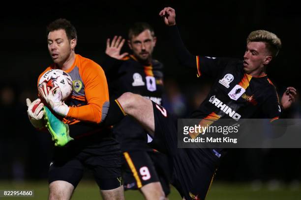 Bankstown Berries goalkeeper Chad Taylor is challenged by Matthew Dawber of the MetroStars during the FFA Cup round of 32 match between Bankstown...