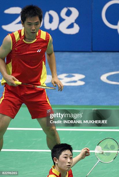 He Hanbin of China looks on as partner Yu Yang hits a return against Nadiezda Kostiuczyk and Robert Mateusiak of Poland in the mixed doubles...