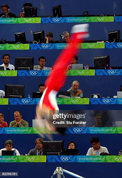 Kohei Uchimura of Japan competes on the bar exercise in front of the press tribune during the men's individual all-around final in the artistic...