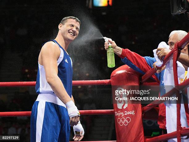 Hungary's Imre Szello is sprayed by his coach after being declared winner defeating Venezuela's Luis Gonzalez during their 2008 Olympic Games Light...