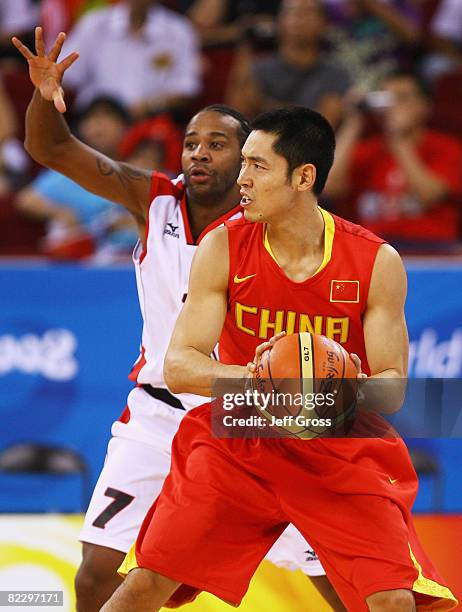 Zhang Qingpeng of China is shadowed by Milton Barros of Angola during the Men's Preliminary Round Group B basketball game at the Olympic Basketball...