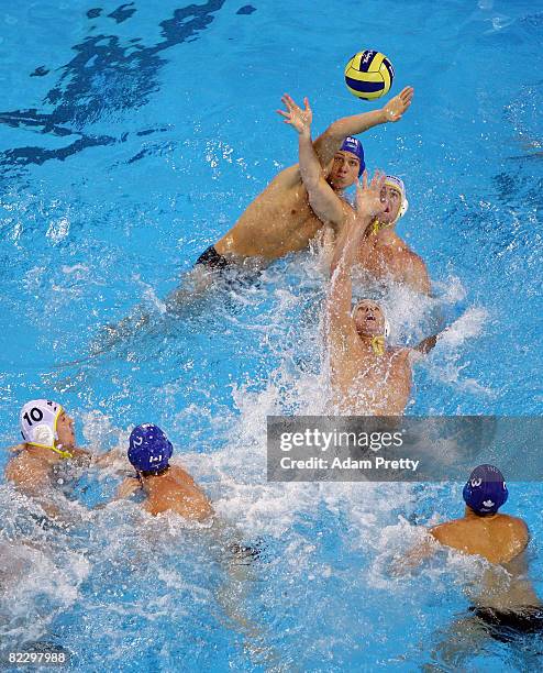 Justin Boyd of Canada goes after the ball over Pietro Figlioli and Sam McGregor of Australia in the men's preliminary water polo event at the Olympic...