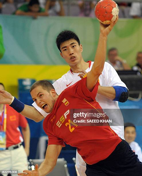 Cristian Malmagro of Spain shoots a goal after dodging Yan Liang of China during their 2008 Beijing Olympic Games men's handball match on August 14,...
