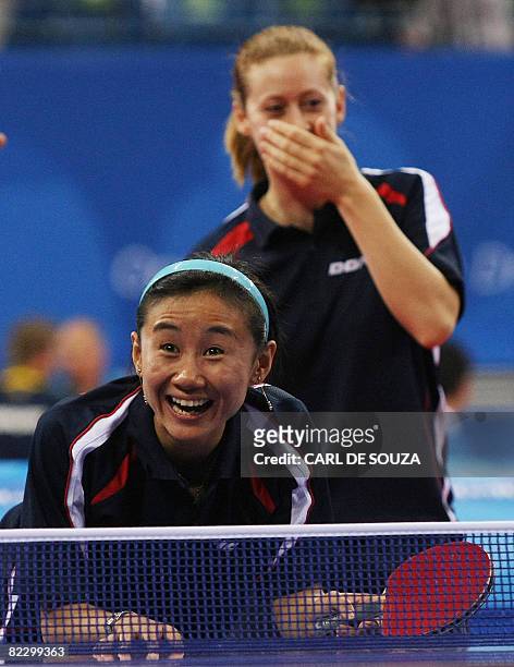 Austria's Liu Jia and Veronika Heinze share a joke as they play against China's Yue Guo and Yining Zhang during their 2008 Beijing Olympic Games...