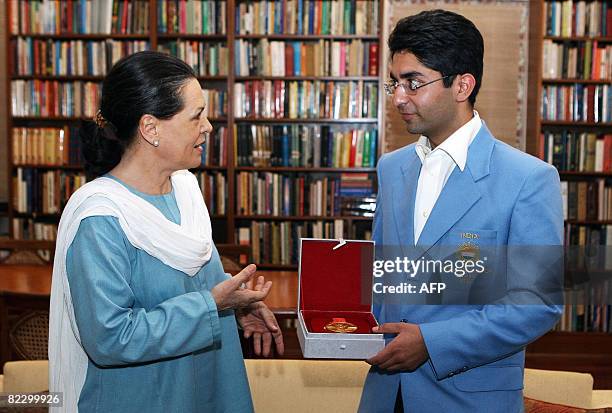 Gold medal winner for the Men's 10m Air Rifle competition at the 2008 Beijing Olympic Games Abhinav Bindra shows his gold medal to Congress President...