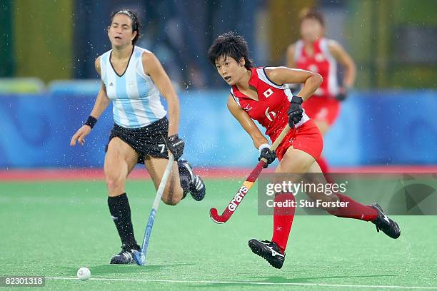 Rika Komazawa of Japan move against the defense of Mariana Gonzalez Oliva of Argentina during the women's pool hockey match at the Olympic Green...