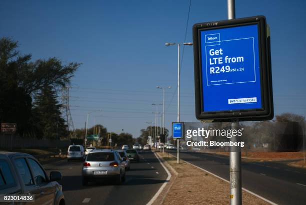 Vehicles pass advertising signs for mobile phone deals from Telkom SA SOC Ltd. On a road in Pretoria, South Africa, on Tuesday, July 25, 2017. South...