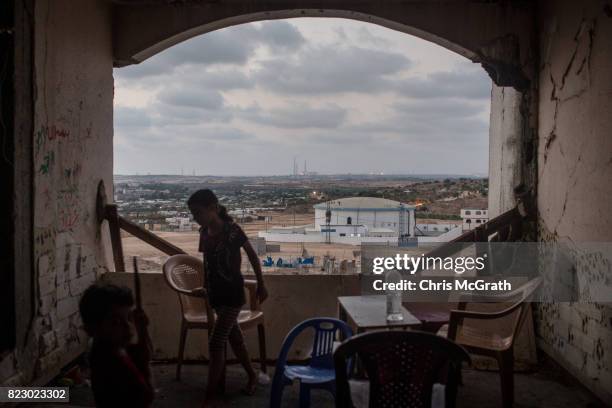 Children are seen outside their home in a destroyed building in the Beit Lahia neighborhood on July 24, 2017 in Gaza City, Gaza. For the past ten...