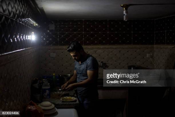 Hassan Ahmed is seen in his kitchen during a power outage in the Beit Lahia neighborhood on July 24, 2017 in Gaza City, Gaza. For the past ten years...