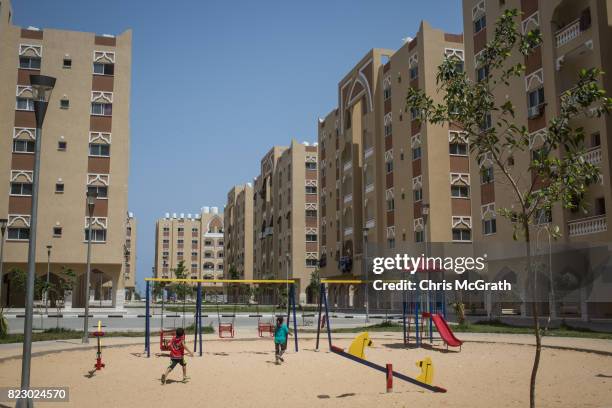 Children play amongst the newly built apartment blocks of the Qatari-funded Sheikh Hamad residential project in Khan Younis on July 24, 2017 in Khan...