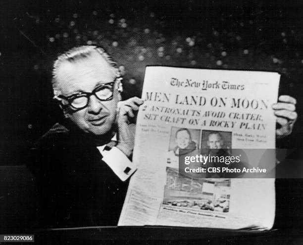 Anchor Walter Cronkite holds up The New York Times during the Apollo 11 telecast, July 20, 1969 at 10:11 PM.