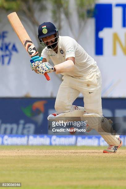 Indian cricketer Cheteshwar Pujara plays a shot during the 1st Day's play in the 1st Test match