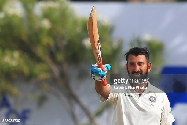 Indian cricketer Cheteshwar Pujara celebrates after scoring 100 runs during the 1st Day's play in the 1st Test match