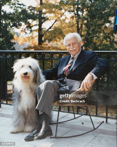 Portrait of American conductor Arthur Fiedler as he sits in a rocking chair, his sheepdog Sebastian at his side, Boston Massachussetts, 1978.