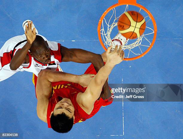 Yao Ming of China dunks the ball over Leonel Paulo of Angola during the Men's Preliminary Round Group A basketball game at the Olympic Basketball...