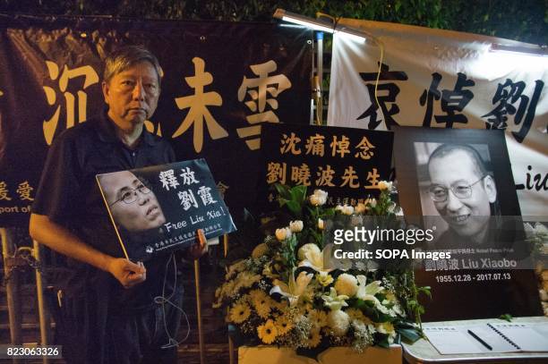 Man seen holding a plea card for Liu Xioabo. Residents of Hong Kong hosted a vigil service outside the Chinese Liaison Office of Hong Kong after the...