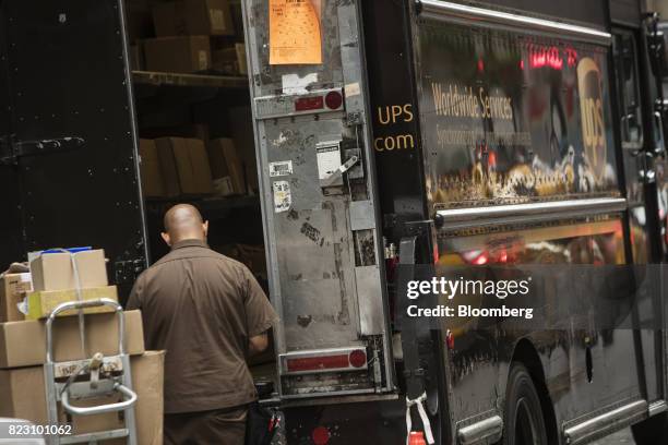 United Parcel Service Inc. Delivery driver loads packages onto a delivery truck on a street in New York, U.S, on Monday, July 24, 2017. United Parcel...