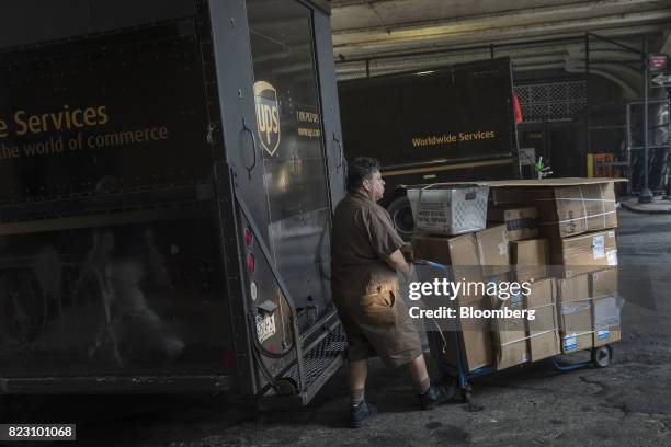 United Parcel Service Inc. Delivery driver pushes a dolly of packages to be delivered past a truck in New York, U.S, on Monday, July 24, 2017. United...