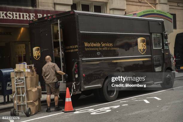United Parcel Service Inc. Delivery driver prepares to load packages onto a delivery truck on a street in New York, U.S, on Monday, July 24, 2017....