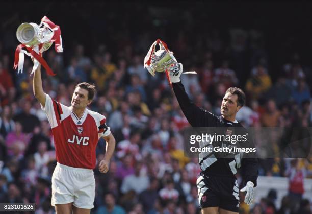 Arsenal captain Tony Adams and goalkeeper David Seaman show off the previous seasons trophys before the FA Premiership match against Everton at...