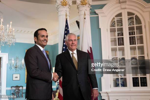 Qatari Foreign Minister Sheikh Mohammed Bin Abdulrahman Al Thani and U.S. Secretary of State Rex Tillerson shake hands during a brief media...