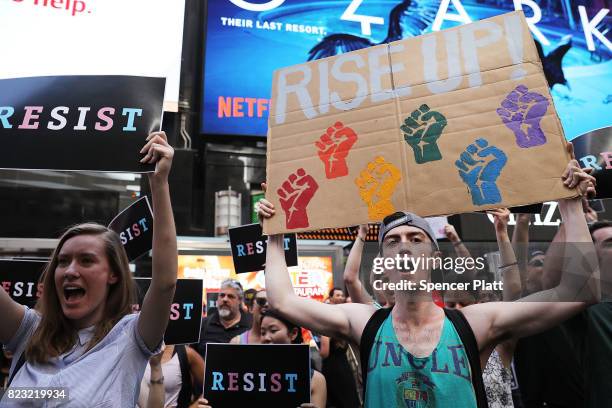 Dozens of protesters gather in Times Square near a military recruitment center to show their anger at President Donald Trump's decision to reinstate...