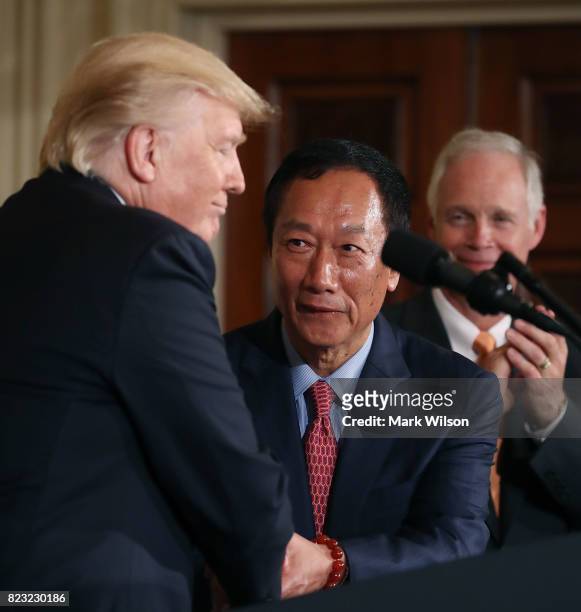 President Donald Trump shakes hands with Terry Gou , Chairman of Foxconn, an electronics supplier, while Sen. Ben Johnson stands nearby during an...