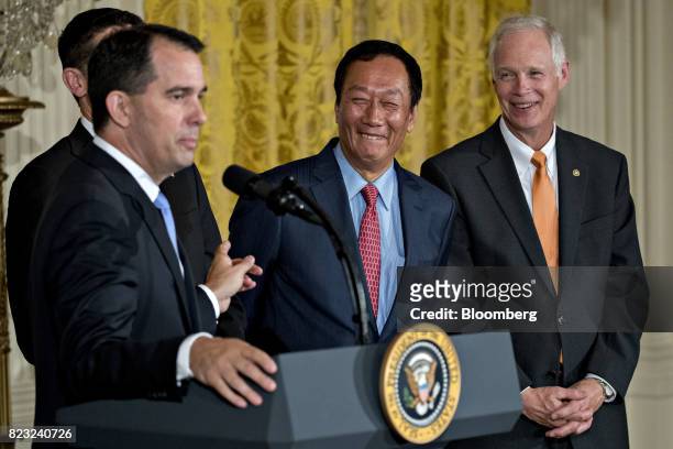Billionaire Terry Gou, chairman of Foxconn Technology Group, center, and Senator Ron Johnson, a Republican from Wisconsin, right, smile as Scott...