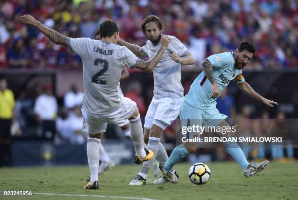 Lionel Messi of Barcelona moves the ball past Victor Lindelöf and Daley Blind of Manchester United during their International Champions Cup football...