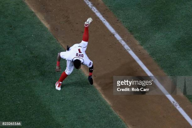 Wilmer Difo of the Washington Nationals trips on the base path while coming into score a run in the eighth inning against the Milwaukee Brewers at...