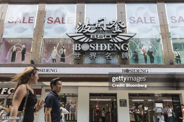 Pedestrians walk past the Bosideng International Holdings Ltd. Flagship clothing store in Shanghai, China, on Friday, July 14, 2017. Bosideng, a...