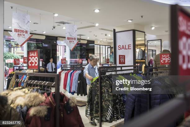 Customer looks at jackets inside the Bosideng International Holdings Ltd. Flagship clothing store in Shanghai, China, on Friday, July 14, 2017....