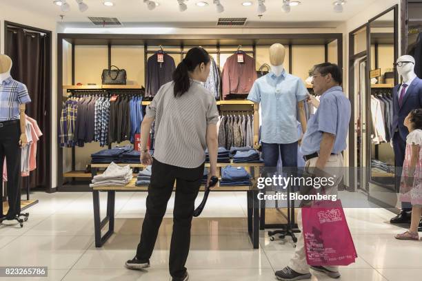 Customer looks at a shirt inside the Bosideng International Holdings Ltd. Flagship clothing store in Shanghai, China, on Friday, July 14, 2017....