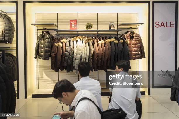 Down jackets hang on display inside the Bosideng International Holdings Ltd. Flagship clothing store in Shanghai, China, on Friday, July 14, 2017....