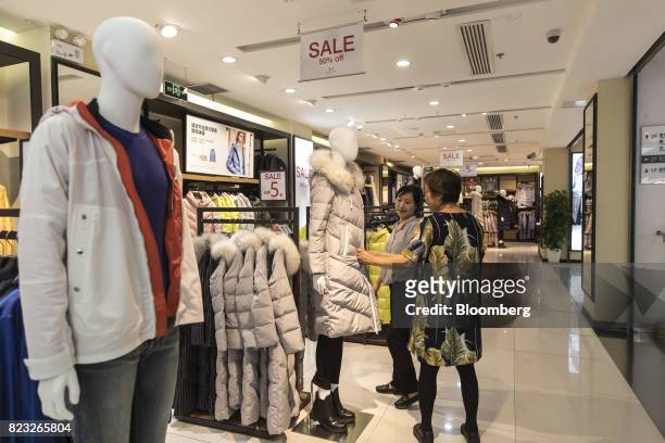 Customer looks at a down jacket displayed inside the Bosideng International Holdings Ltd. Flagship clothing store in Shanghai, China, on Friday, July...