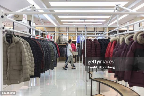 Customers walk past down jackets displayed inside the Bosideng International Holdings Ltd. Flagship clothing store in Shanghai, China, on Friday,...