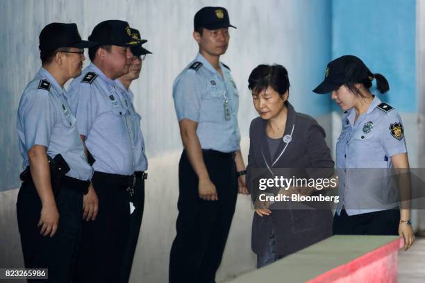 Park Geun-hye, former president of South Korea, second right, is escorted by a prison officer as she arrives at the Seoul Central District Court in...