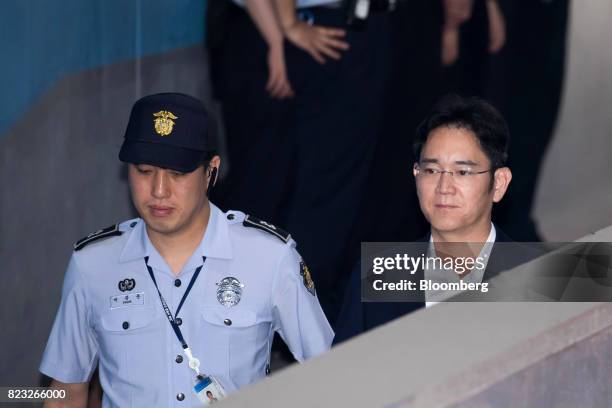 Jay Y. Lee, co-vice chairman of Samsung Electronics Co., right, is escorted by a prison officer as he arrives at the Seoul Central District Court in...