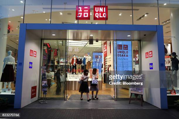 Shoppers exit a Uniqlo store, operated by Fast Retailing Co., in Osaka, Japan, on Wednesday, July 26, 2017. Japan is scheduled to release June's...
