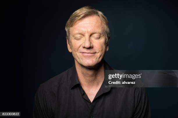 retrato de sonriente hombre maduro con los ojos cerrados - ojos cerrados fotografías e imágenes de stock