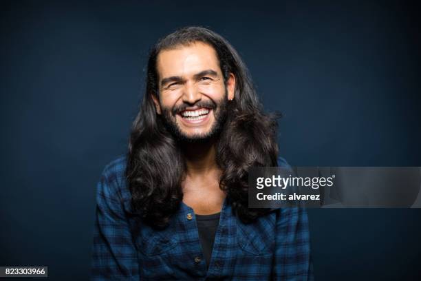 porträt von fröhlichen jungen mann mit langen haaren - langes haar stock-fotos und bilder