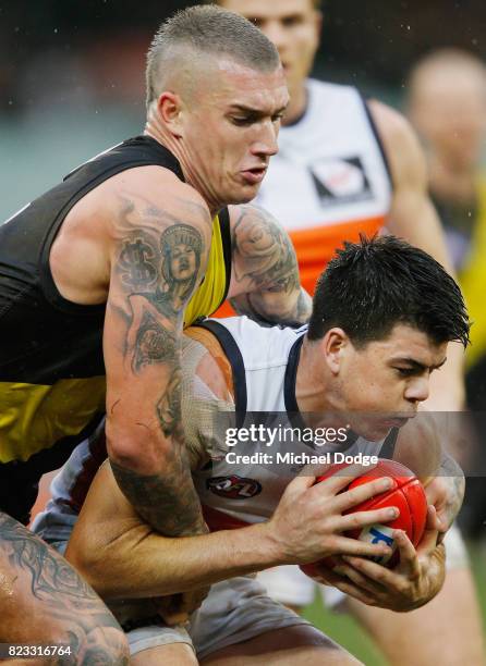 Dustin Martin of the Tigers tackles Will Settlefield of the Giants during the round 18 AFL match between the Richmond Tigers and the Greater Western...