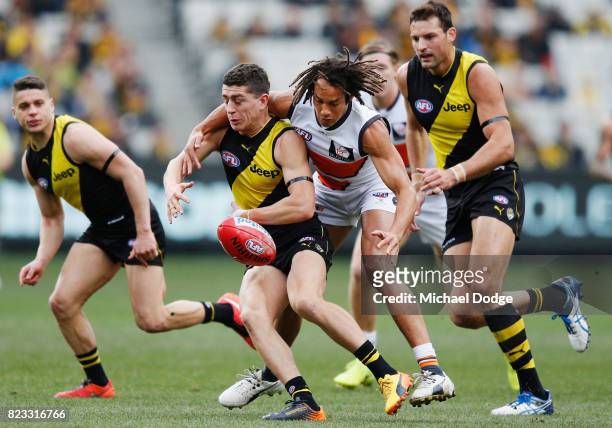 Tendai Mzungu tackles Jason Castagna of the Tigers during the round 18 AFL match between the Richmond Tigers and the Greater Western Sydney Giants at...