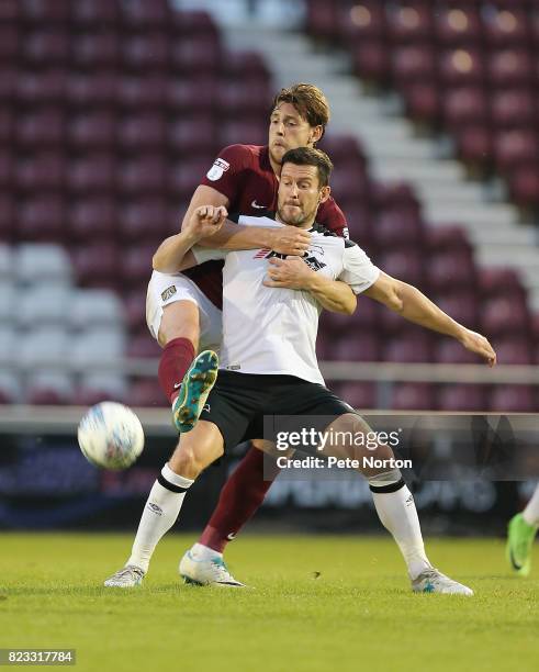 Ash Taylor of Northampron Town contests the ball with David Nugent of Derby County during the Pre-Season Friendly match between Northampton Town and...