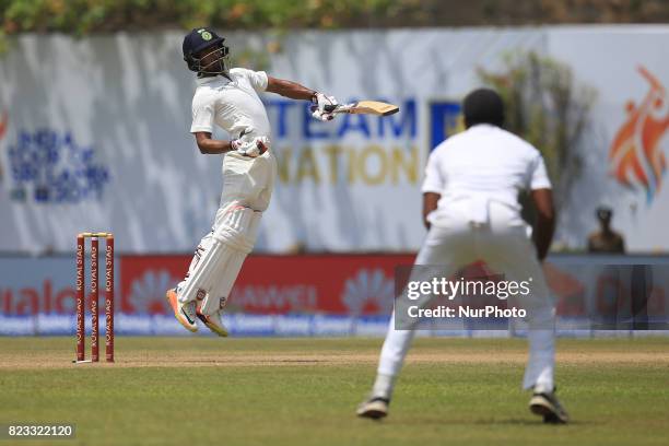 Indian cricketer Wriddhiman Saha reacts as he leaves a bouncer ball during the 2nd Day's play in the 1st Test match between Sri Lanka and India at...