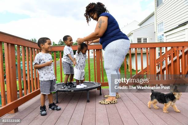 Keisha Carney helps Mekhi, her E-sure baby, play with his siblings Malik, left, and Khalil while Diggy, the dog, checks out who is at the door May...