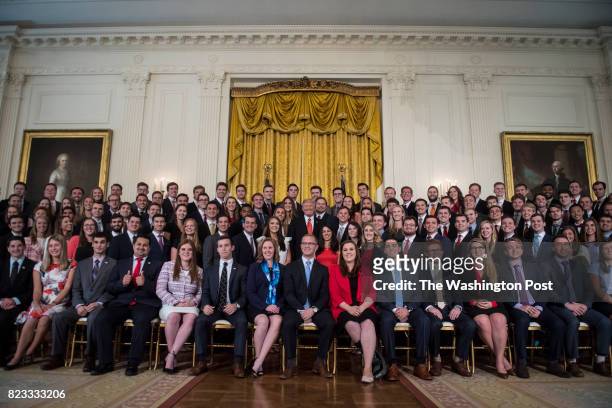 President Donald Trump speaks while posing for a photo with outgoing White House interns in the East Room of the White House in Washington, DC on...