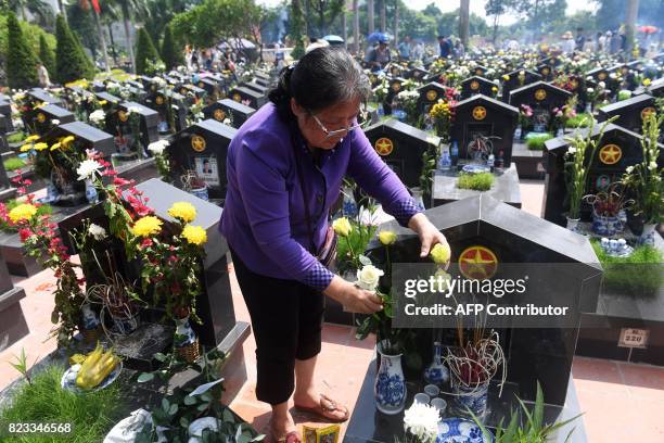 Woman places roses on the grave of a relative at an official cemetery in Hanoi on July 27 as Vietnam marks the National Day for war martyrs and...